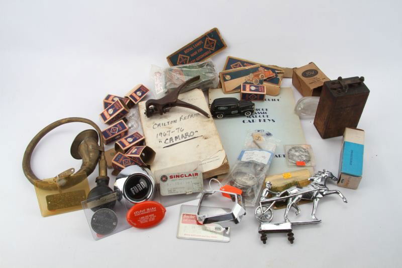EX DEALERS STOCK OF ANTIQUE & VINTAGE CAR PARTS: Varied collection of automobile parts and other car related items includes, 1927 Georgia vehicle aluminum registration tag, 1954 Ford grill ornament, Sulky driver hood ornament, set of Royal auto lamp