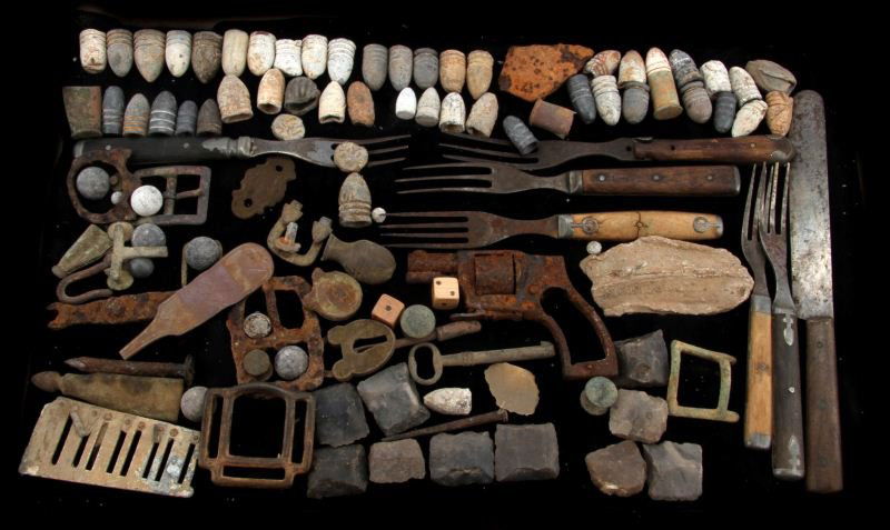 CIVIL WAR CAMPSITE METAL DETECTOR & DUG ARTIFACTS: Frame full of Civil War and later dug items, scabbard chape, Minnie Balls, some carved into game pieces, nice collection of cutlery, and more.