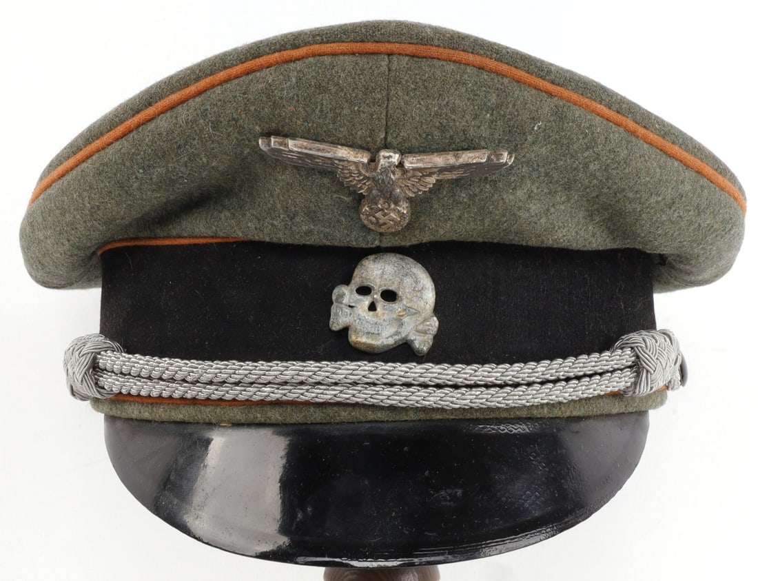 WWII GERMAN CONCENTRATION CAMP VISOR: Field grey visor with concentration camp color piping. Totenkopf is zinc with clear age. Eagle appears to be silver plated. Very good condition overall. Diameter of headband measures 7 1/4 inches in i