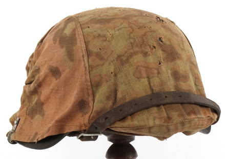 WWII GERMAN SS CKL62 M42 STEEL HELMET & CAMO COVER: Waffen-SS M42 steel combat helmet with reversible camouflage cover or Helmbezug. Helmet is complete, retaining liner, chinstrap, liner band and rivets. Interior of helmet stamped "CKL62 532" at neck.
