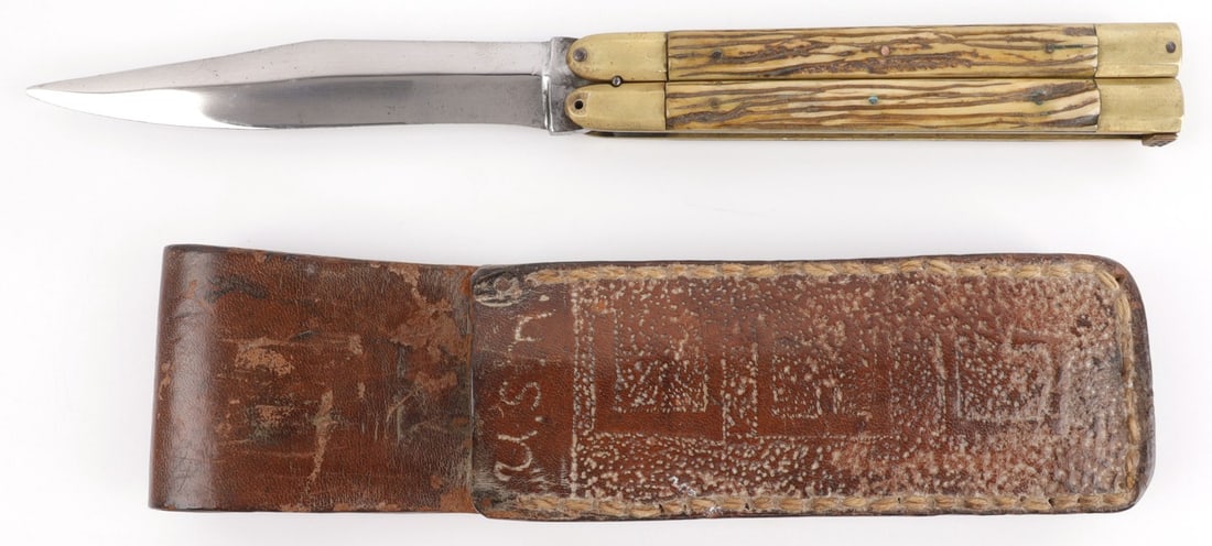 WWII USMC BALISONG JIGGED BONE FOLDING KNIFE: Steel blade butterfly knife with jigged bone grips and brass bolsters. Includes leather sheath inscribed "USMC CEG." Overall length: 6 inches (closed). 4.75-inch blade. Good condition. Missing one pin