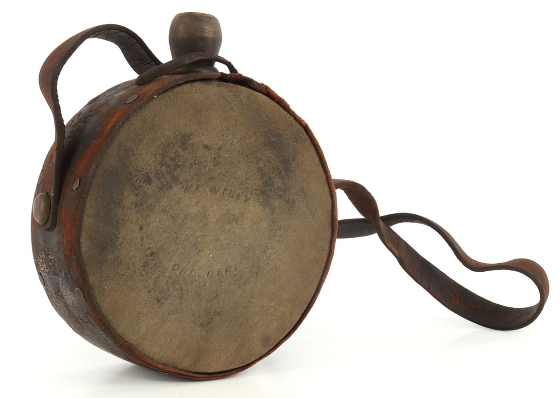 WAR OF 1812 US NAMED CANTEEN ORDNANCE DEPARTMENT: Canteen from the War of 1812. Stamped 'W. C. Wiley' and 'Ord. Dept' on intact cloth cover. Leather bind, leather carrying strap. Spout intact, stopper missing. 7.5-inch diameter, 3-inch thickness. Ver