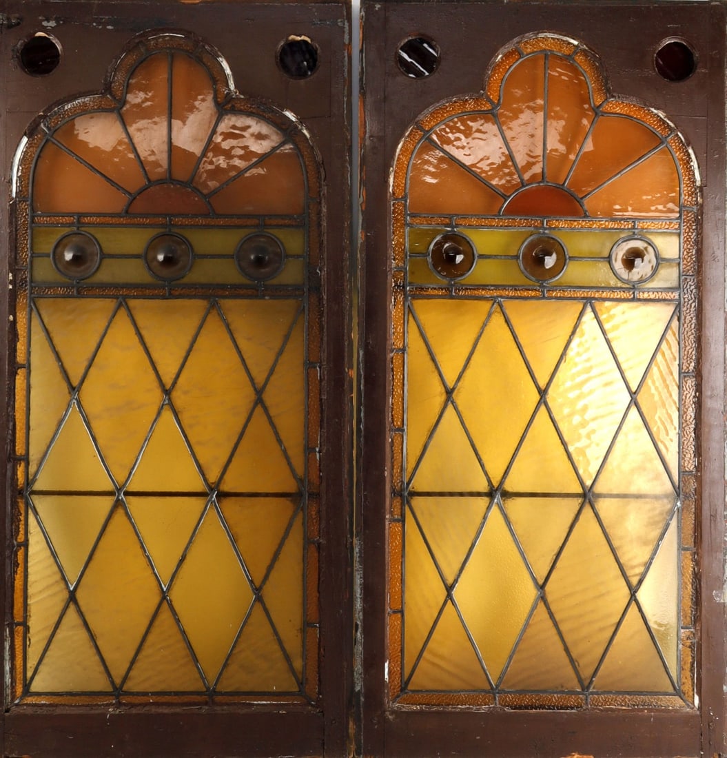 TWO PUB STYLE PANELS WITH STAINED GLASS INSERTS: Two panels, both rustic in character and design, with stained glass inserts. The stained glass varies in yellows and oranges, likely designed to create a warmer and more homey environment than other p