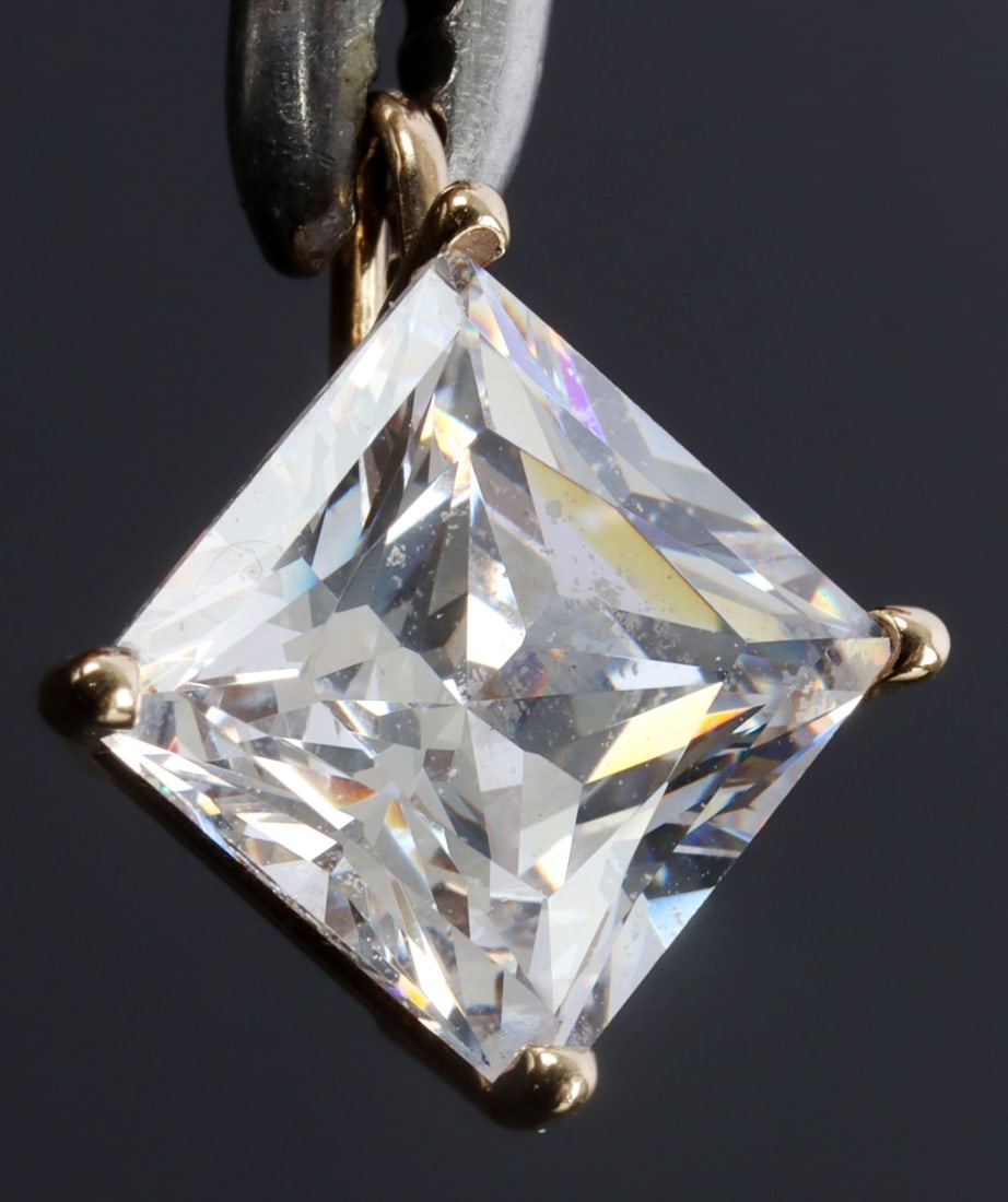 10KT YELLOW GOLD PENDANT & SIMULATED DIAMOND: Simulated diamond travel pendant in 14kt yellow gold. 1 gram. Stone measures 7mm with a depth of approx. 5.2mm. Marked 10KT. This lot has a reserve.