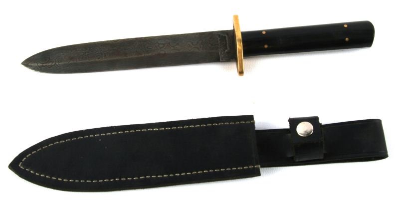 REPRO ROGERS & SONS DAMASCUS BOWIE KNIFE: 7 inch blade Damascus-patterned spear point blade, marked with cross and star and “Norfolk St Sheffield England” with brass guard, black composite handle, and black leather scabbard. In very good 