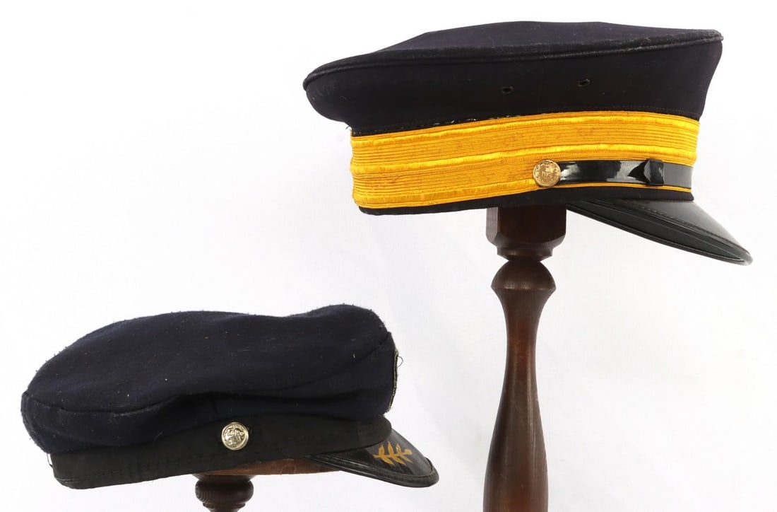 PILOT AND JUNIOR PILOT CAP LOT OF 2: Lot of two (2). Pilot's cap. Dark blue with gold strap on front, black leather band supported by brass buttons marked 'D.' Interior is marked "Wentworth 'Head-Master"' Made for Thurman the Tailor Memp