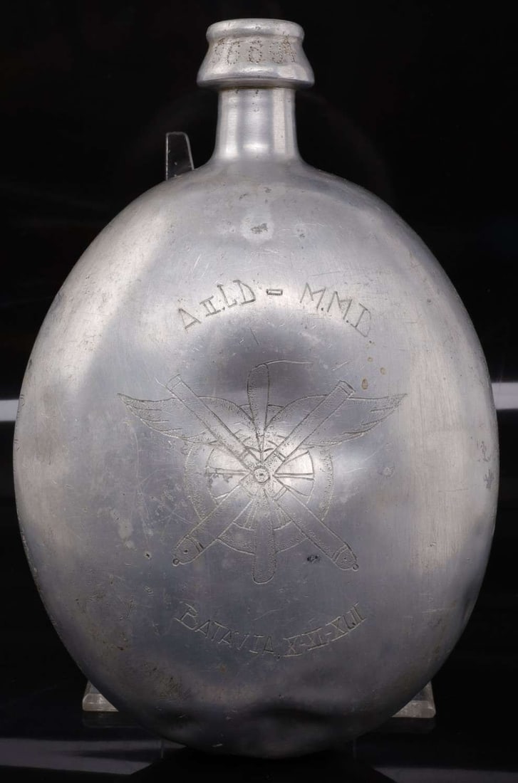 WWI BELGIUM CARVED CANTEEN DEPICTING BATAVIA: Carved Belgian canteen depicting the fall of Batavia. On one side, there is an inscription reading Batavia and the date of its fall to the Japanese. On the other, a drawing of a Japanese soldier captu