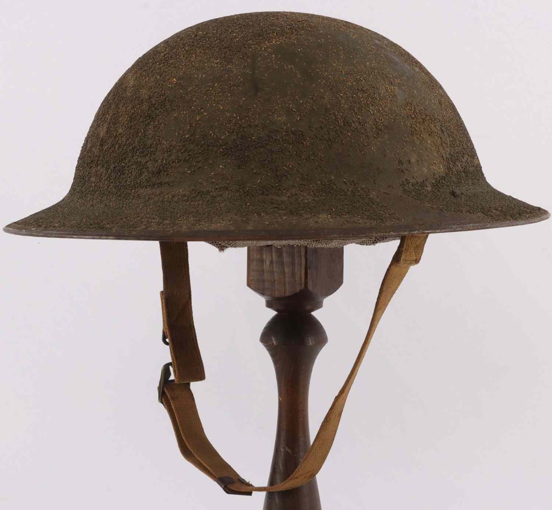 WWI COMPLETE US M1917 BRODIE STEEL COMBAT HELMET: US M1917 steel combat helmet, complete, with padded leather liner and chinstrap. Painted cork exterior. Interior has heat stamp "ZA 263" at visor. Liner is marked "'Bud' Nov 18, 1939, Camp Jackson, So