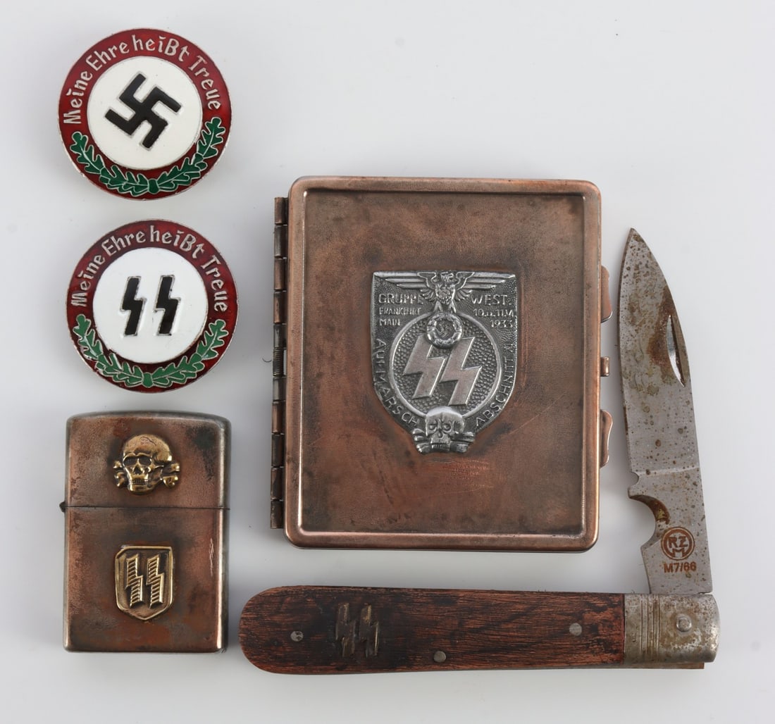 WWII GERMAN THIRD REICH PERSONAL EFFECTS LOT OF 7: 1) An SS Berlin hands tamp. 2) An SS Wewelsburg hand stamp. 3) A Zippo-style lighter with SS and Totenkopf decals. 4) A cigarette case with SS-Siegrunes and a Reichsadler. 5) A pocket knife with SS-Si