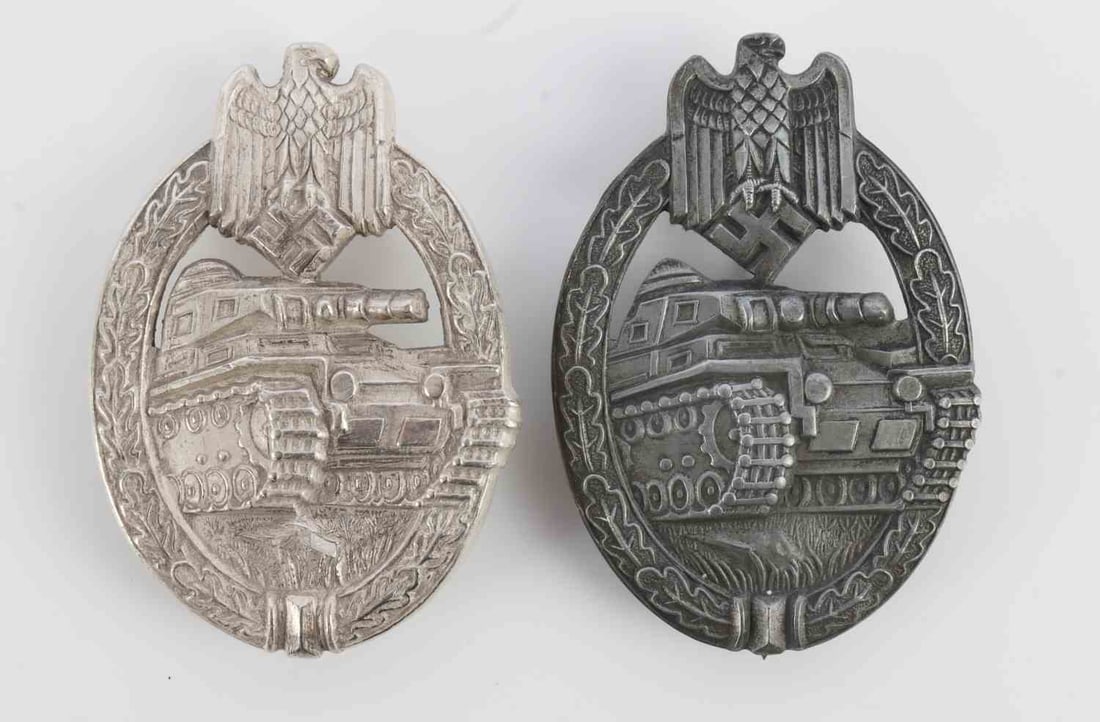 2 WWII GERMAN THIRD REICH PANZER ASSAULT BADGE: Two badges with 1 being late war hollow type in zinc. The other is a heavy type H. Aurich piece with ball hinge. This lot has a reserve.
