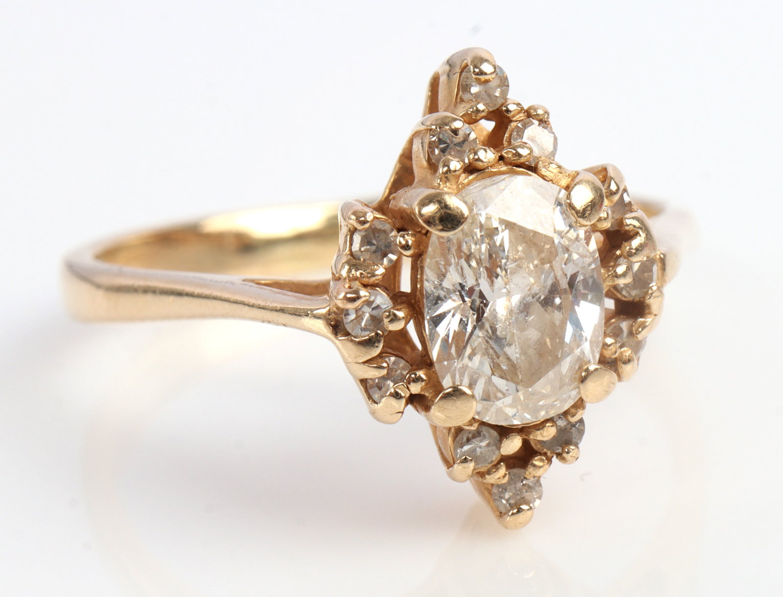.5 CT OVAL DIAMOND YELLOW GOLD HALO RING: Center diamond 6.81 X 5mm. Depth approximately 2.9mm. Small scratches on table. Slightly included in clarity and color approximately D - F in color. Flanked by melee diamonds. Set in 14kt yellow gold.