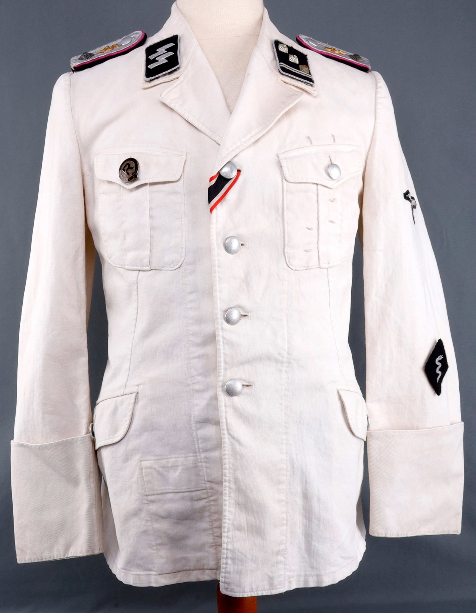 WWII GERMAN WAFFEN SS SUMMER DRESS TUNIC: Rare SS Veterinarian tunic. Complete with shoulder boards, collar tabs, sleeve insignia, pebbled Assmann buttons, and pin. Pips appear to be silver or plated. Insignia measures 3 inches. Tunic does no