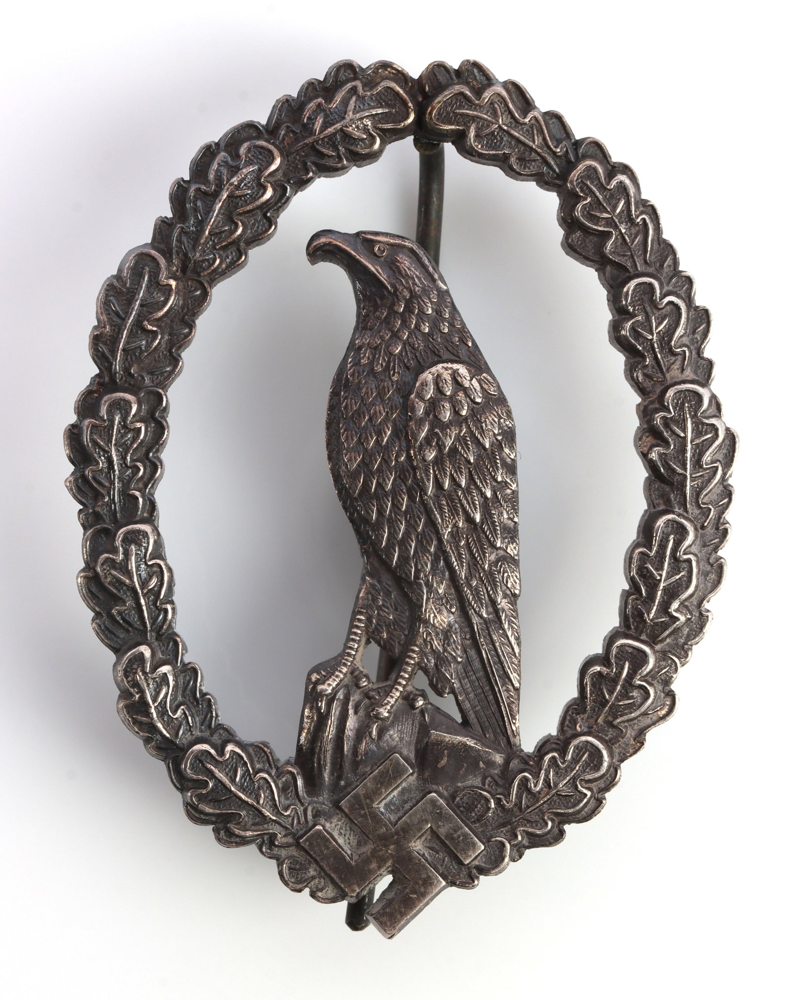 WWII GERMAN REICH LUFTWAFFE RETIRED PILOT BADGE: A retired Luftwaffe pilot badge from the Third Reich. Shows a Luftwaffe eagle resting on a swastika, mounted on a wreath. In silver. Juncker marked. Very good condition.