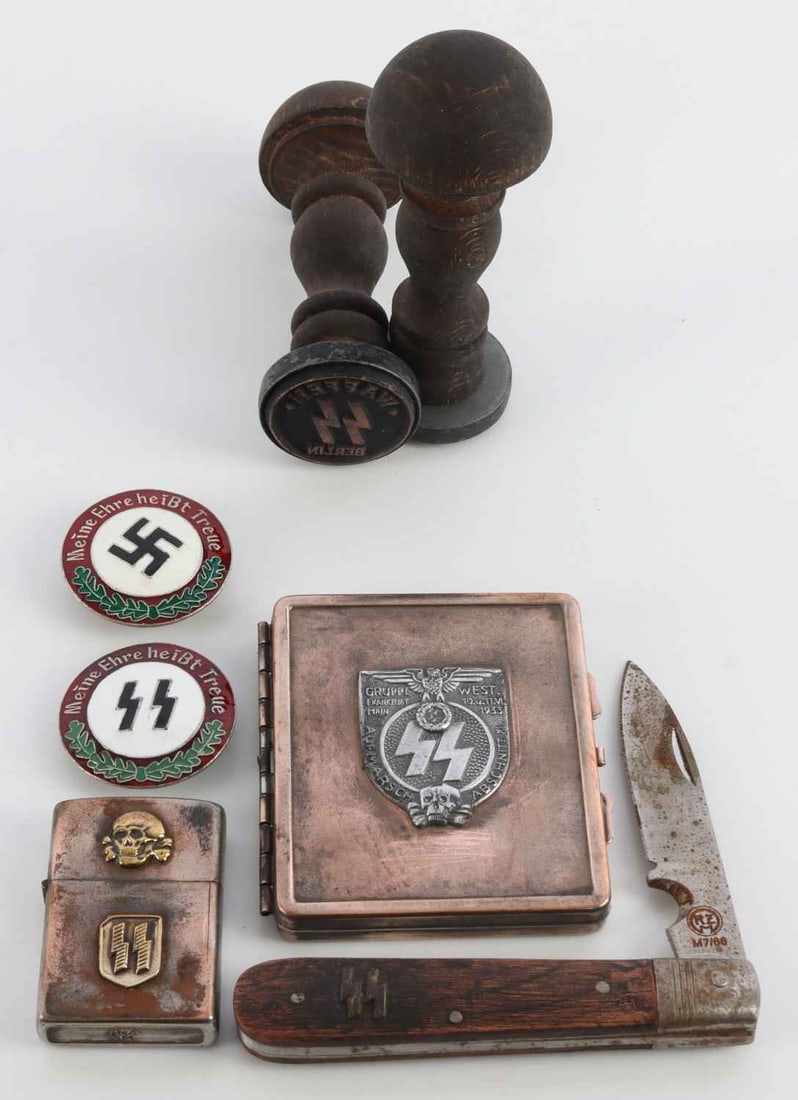 WWII GERMAN THIRD REICH PERSONAL EFFECTS LOT OF 7: 1) An SS Berlin hands tamp. 2) An SS Wewelsburg hand stamp. 3) A Zippo-style lighter with SS and Totenkopf decals. 4) A cigarette case with SS-Siegrunes and a Reichsadler. 5) A pocket knife with SS-Si