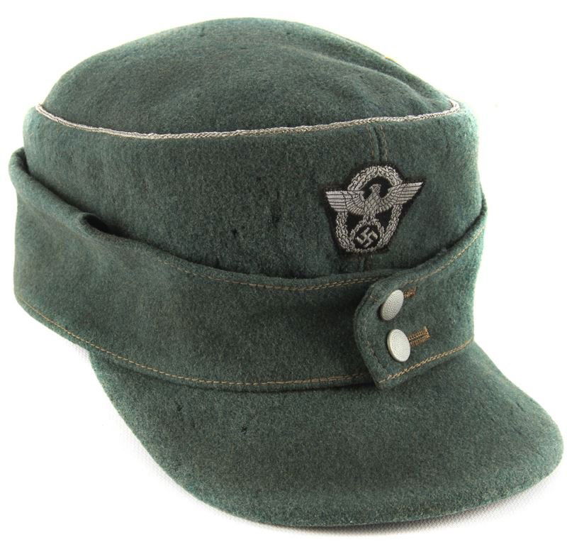 GERMAN WWII POLICE OFFICER CAP M-43: Police Officer M-43 of a green wool with pull-down sides and a silver wire cord piped crown. Machine sewn embroidered silver-gray eagle/swastika/wreath – on a black background. Gray leather sweatban