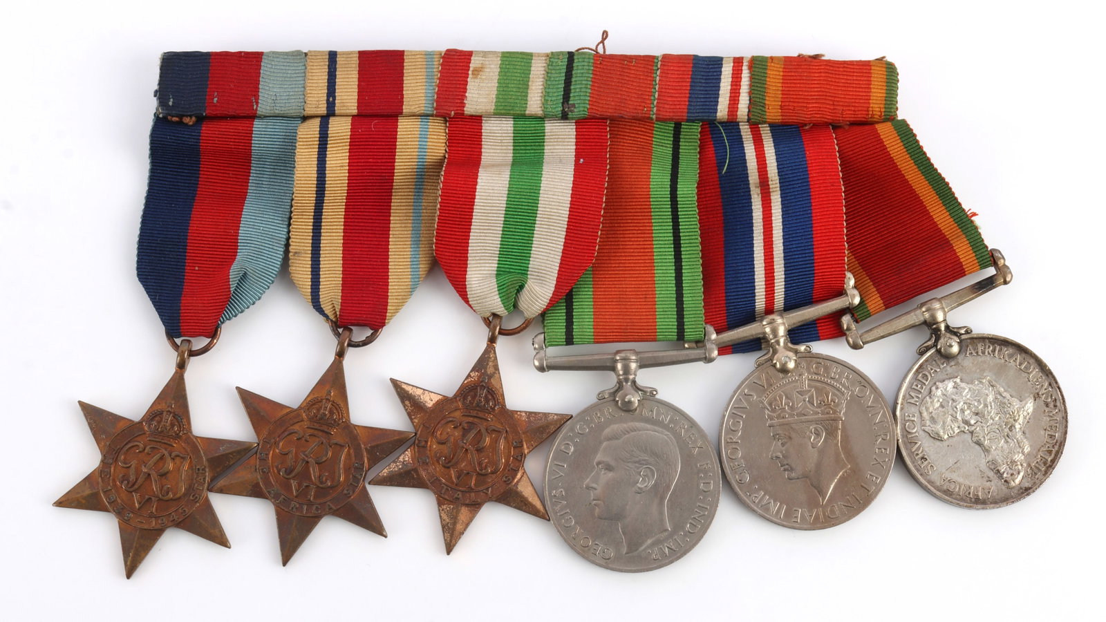 WWII BRITISH NAMED SIX PLACE MEDAL BAR AFRICA: British six-place medal bar. All medals engraved "M25548 G.I. De Klerk." Includes 1939?1945 Star, Africa Star, Italy Star, Defence Medal, War Medal 1939?1945 and Africa Service Medal. Very good condit
