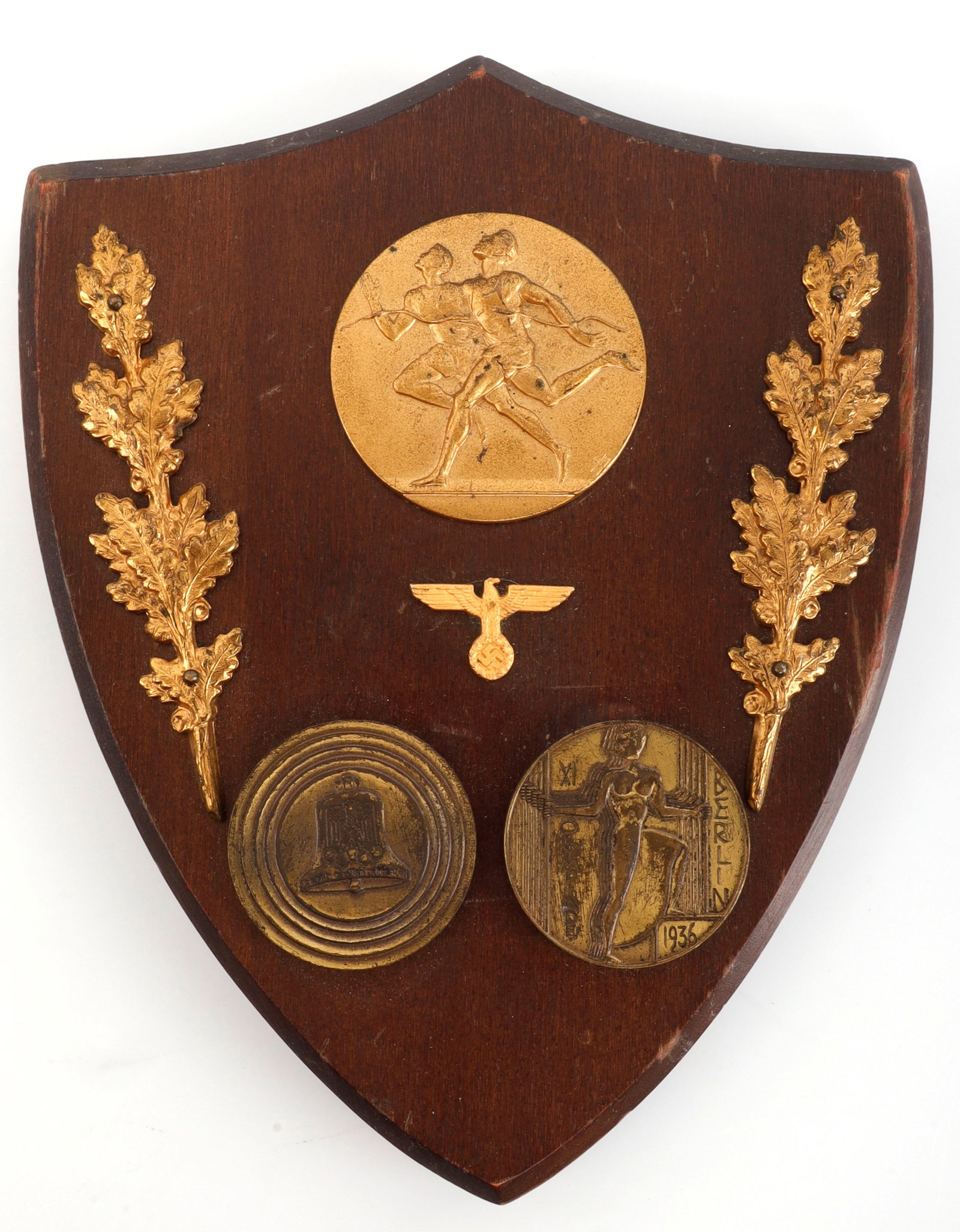 WWII GERMAN THIRD REICH OLYMPIC MEDAL PLAQUE: Wooden plaque with gilt oak leaves and commemorative Olympic medals. It measures 7 1/8 X 5 3/4. Unauthenticated, sold as is.