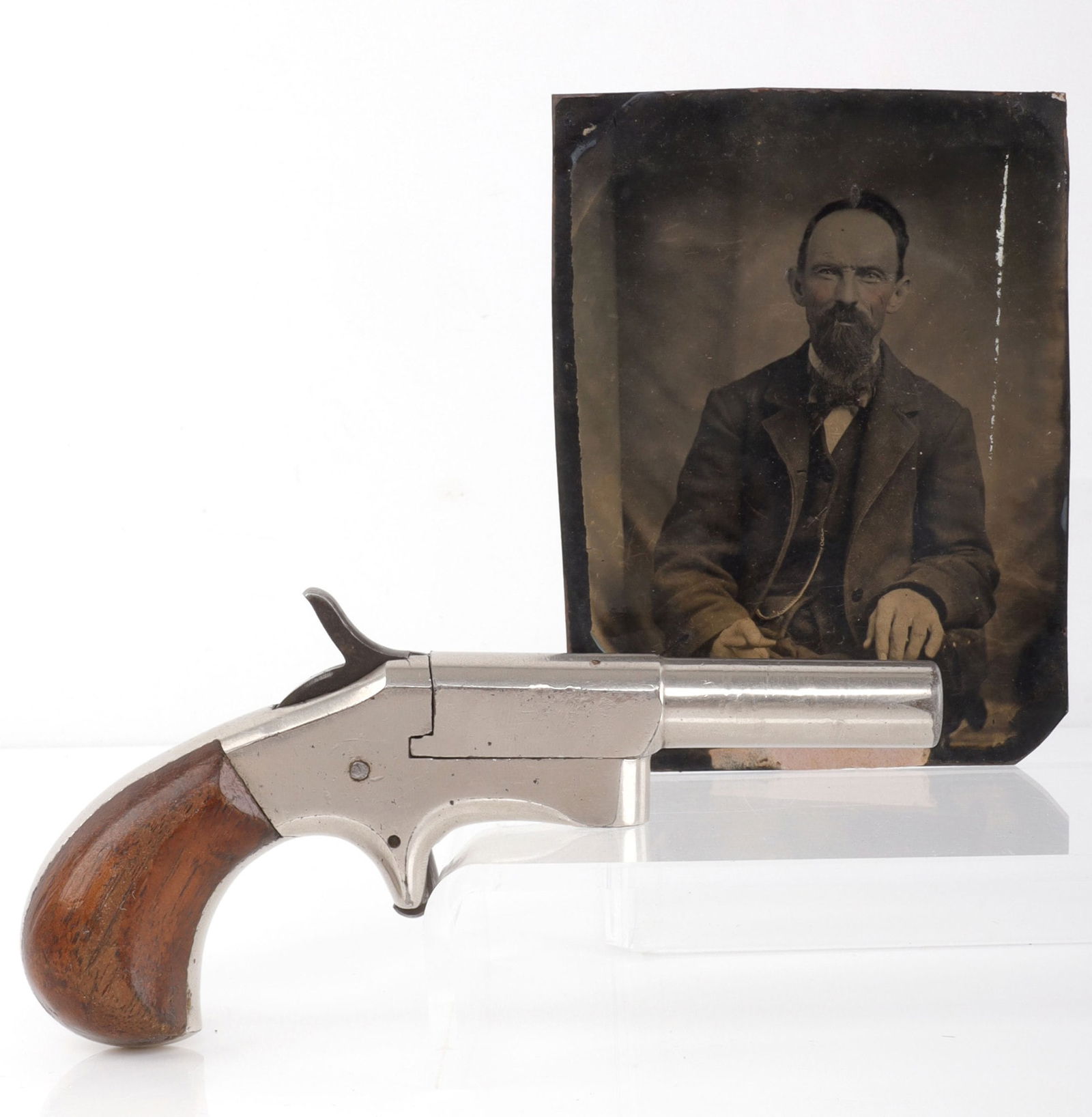 UNMARKED IVER JOHNSON ECLIPSE DERRINGER W/ TINTYPE: Iver Johnson Eclipse .32 rimfire derringer with tintype portrait of a well-dressed man said to be the pistol's owner. Barrel length 2-7/8 inches. Pistol unmarked except for serial on frame. Nickel pla