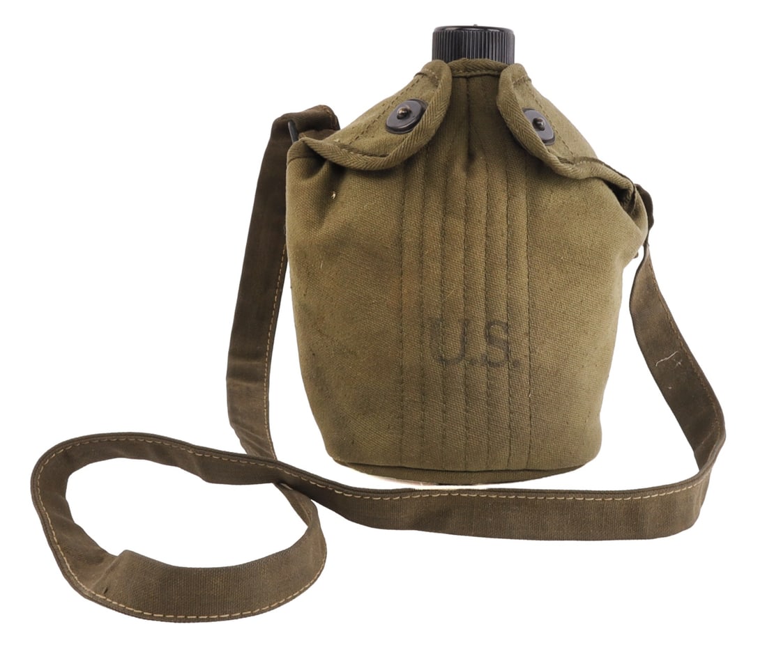 WWII US MARINE CORPS MODEL 1910 CANTEEN: A Model 1910 USMC canteen from the Second World War. Black enamel on canteen proper, dark olive cover, with Bakelite cap. The enamel body of the canteen is unmarked, as is the accompanying tin cup. Th