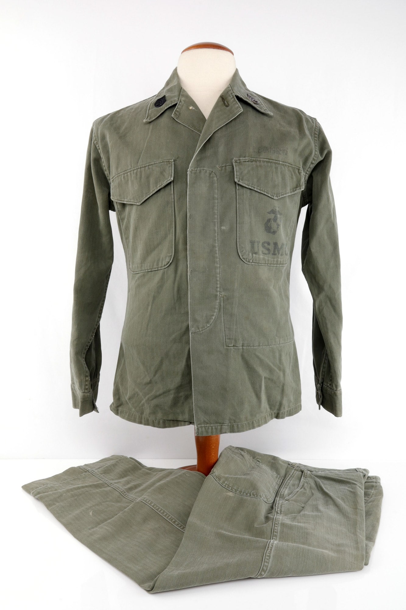USMC MARINES P53 HBT HERRING BONE TWILL UNIFORM: Shirt marked size 34. Named to R.E. Driggers, with Sgt. metal lapel insignia. Trousers size 28-31. Good condition.