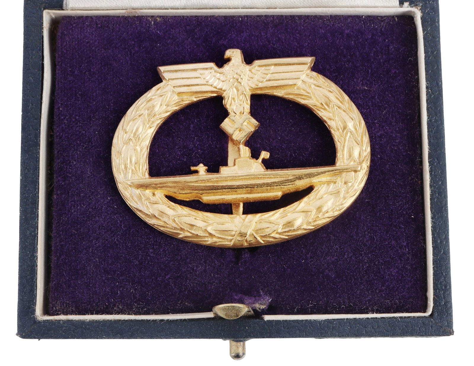 WWII GERMAN REICH U-BOAT BADGE IN BLUE ISSUE CASE: Kriegsmarine U-boat badge. Gilt brass with vertical pin. No maker's mark. Box is from Schwerin. Badge measures 1 7/8 inches. This lot has a reserve.
