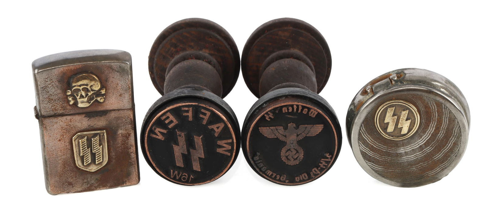 WWII GERMAN REICH STAMPS & PERSONAL EFFECTS LOT 4: A lot of two personal items and two hand stamps from the Third Reich. 1) SS portable ashtray. 2) SS zippo-style lighter. 3) Waffen-SS hand stamp. 4) Waffen-SS 'Germania' hand stamp. Unauthenticated, s