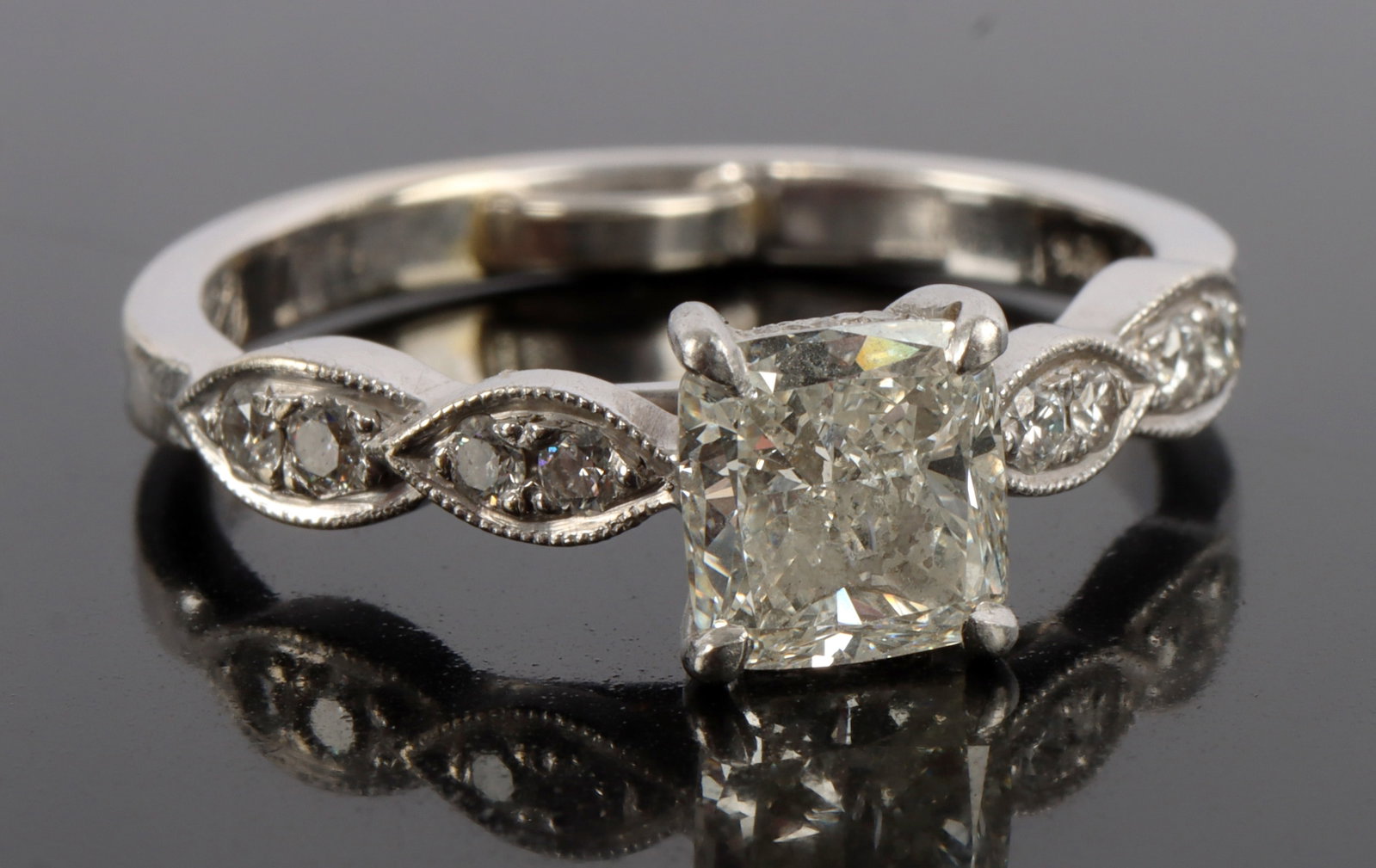 1 CARAT CUSHION CUT DIAMOND IN 14KT WHITE GOLD: Cushion modified brilliant diamond. Weighs 1.01 ct. Measures 6.10 X 5.8 X 3.44mm. Very good polish. SI2 clarity. I in color. Housed in 14kt white gold band size 8. Weighs 3.9 grams. This lot has a res