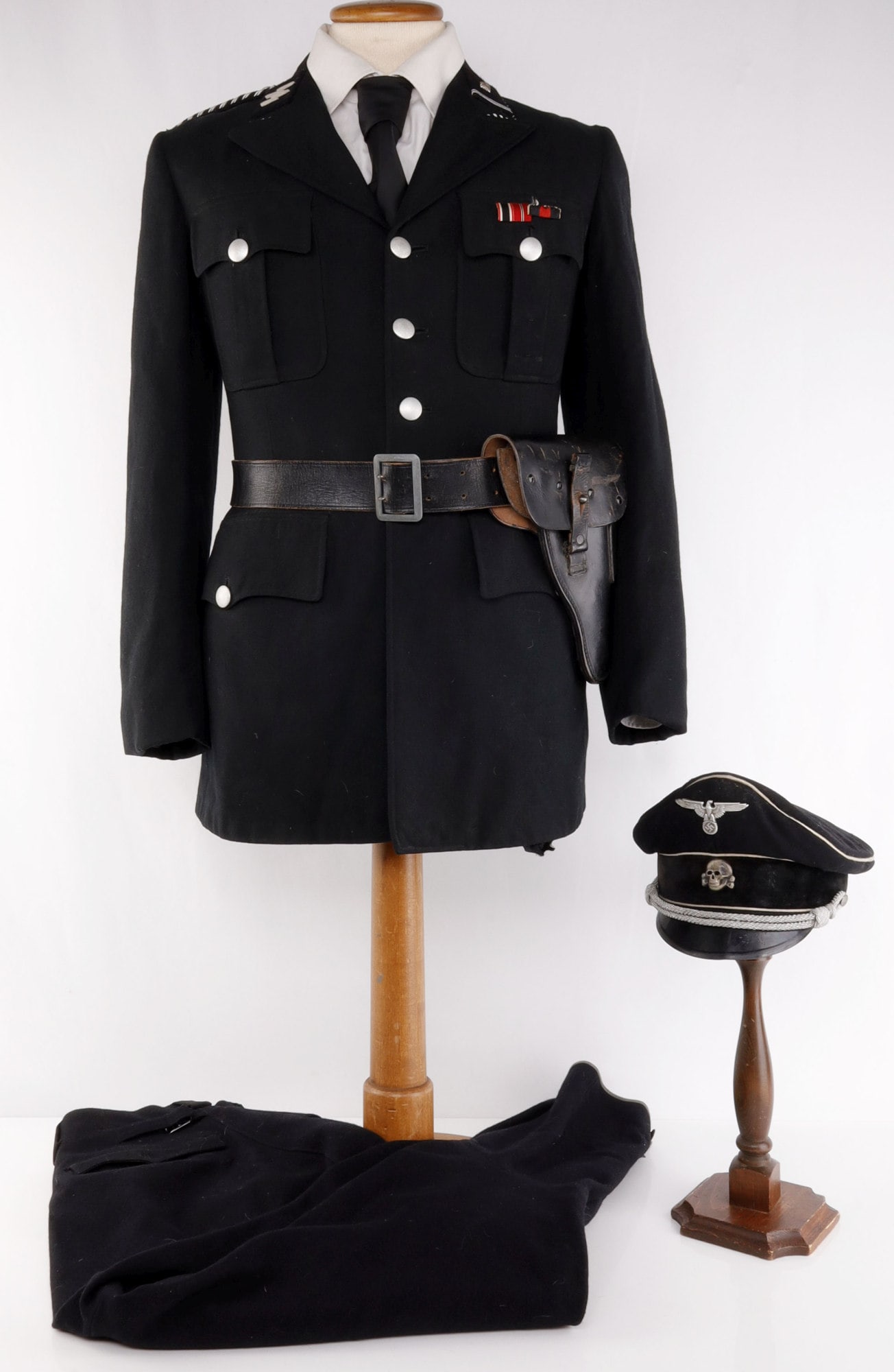 ALLGEMEINE SS OFFICER UNIFORM WWII GERMAN: Peaked visor features aluminum Reichsadler and silver plated totenkopf. Aluminum bullion wire chinstrap. Leather sweat band and silk lining. Interior diameter measures 8 ? inches. Non-fluorescing. The