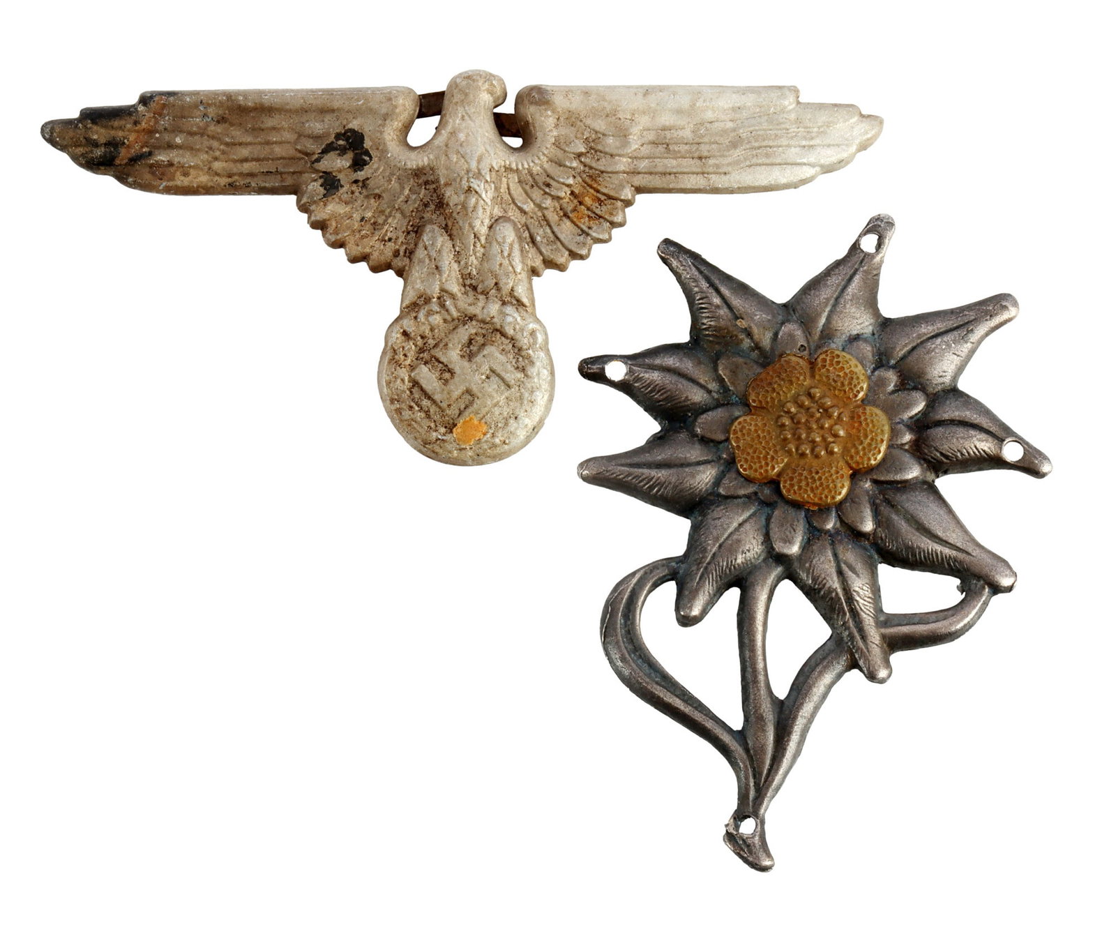 WWII SS VISOR EAGLE & EDELWEISS CAP BADGE INSIGNIA: Lot of two (2) pieces. Waffen-SS visor eagle insignia, unmarked, probably E.W. Assmann & Sohne. Reverse has two flat, horizontal prongs. Width 2.75 inches. Height 1.28 inches. Weight 3.4 grams. Gebirg
