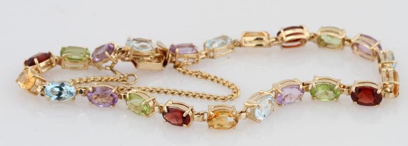 LADIES 14K YELLOW LINK GEM-STONE BRACELET: Colorful bracelet, flexible links, containing 22 oval cut semi-precious stones, each measuring approximately 6x4mm. Including aquamarine, amethyst, citrine, blue topaz, moz garnet and peridot. Box cla