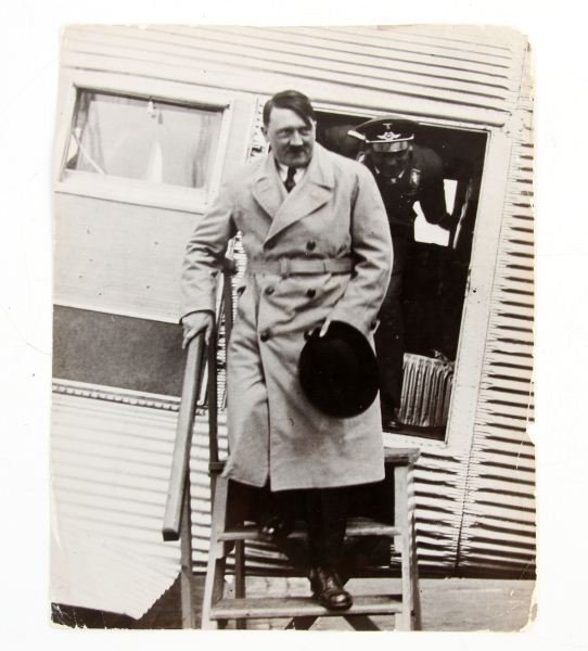 NSDAP ADOLF HITLER PRESS PHOTO WITH PRIVATE PLANE: 7.25 by 9.25 period press photograph of Adolf Hitler disembarking from his private airplane. Reverse has penciled "0A33846" and a tag "Return to / European Picture Service / Paul Thompson Photos / 353