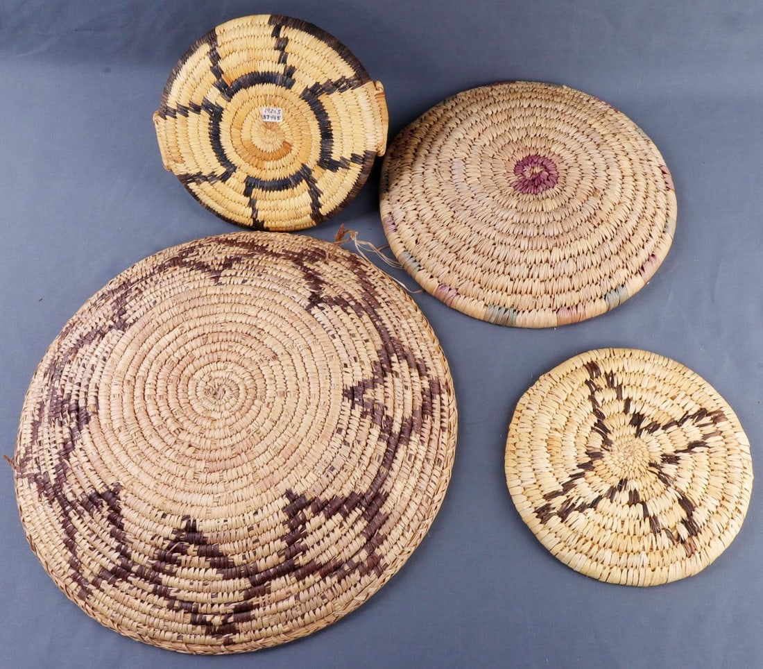 NATIVE APACHE WOVEN TRAYS & BASKET LOT OF 4: Lot of FOUR (4). 1) Large tray with a diamond pattern. 18 inch diameter. 2) Light tray, no design. 11.5 inch diameter. 3) Tray with a star design.8.5 inch diameter. 4) Tray with handle, geometric cros