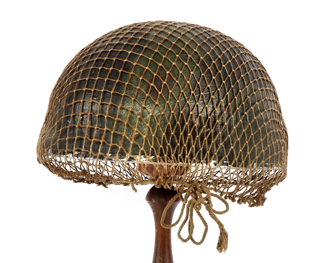 NAMED BRITISH WWII PARATROOPER HELMET: Metal shell complete with liner, chinstrap, and netting. No visible maker's mark. Appears to have name on inner rear. Also numbered on the sweatband. Interior liner diameter measures 8 inches. These h