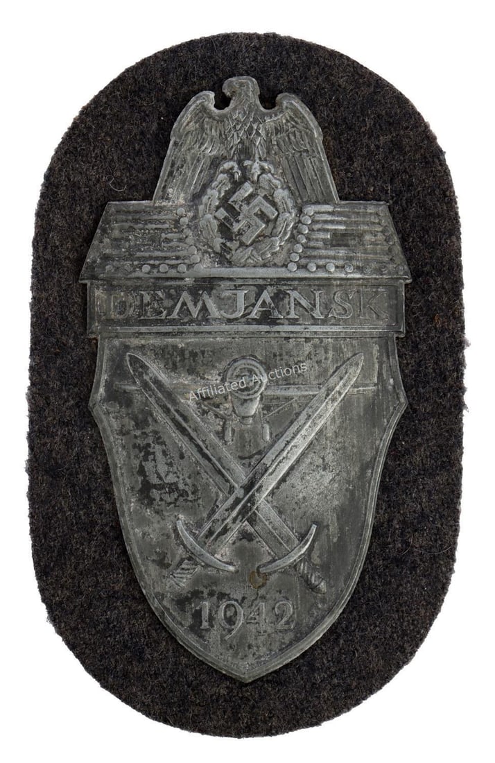 WWII GERMAN THIRD REICH DEMJANSK SHIELD: A Demjansk campaign shield. Shield features a Reichsadler over crossed swords and airplane. Unauthenticated, sold as is.