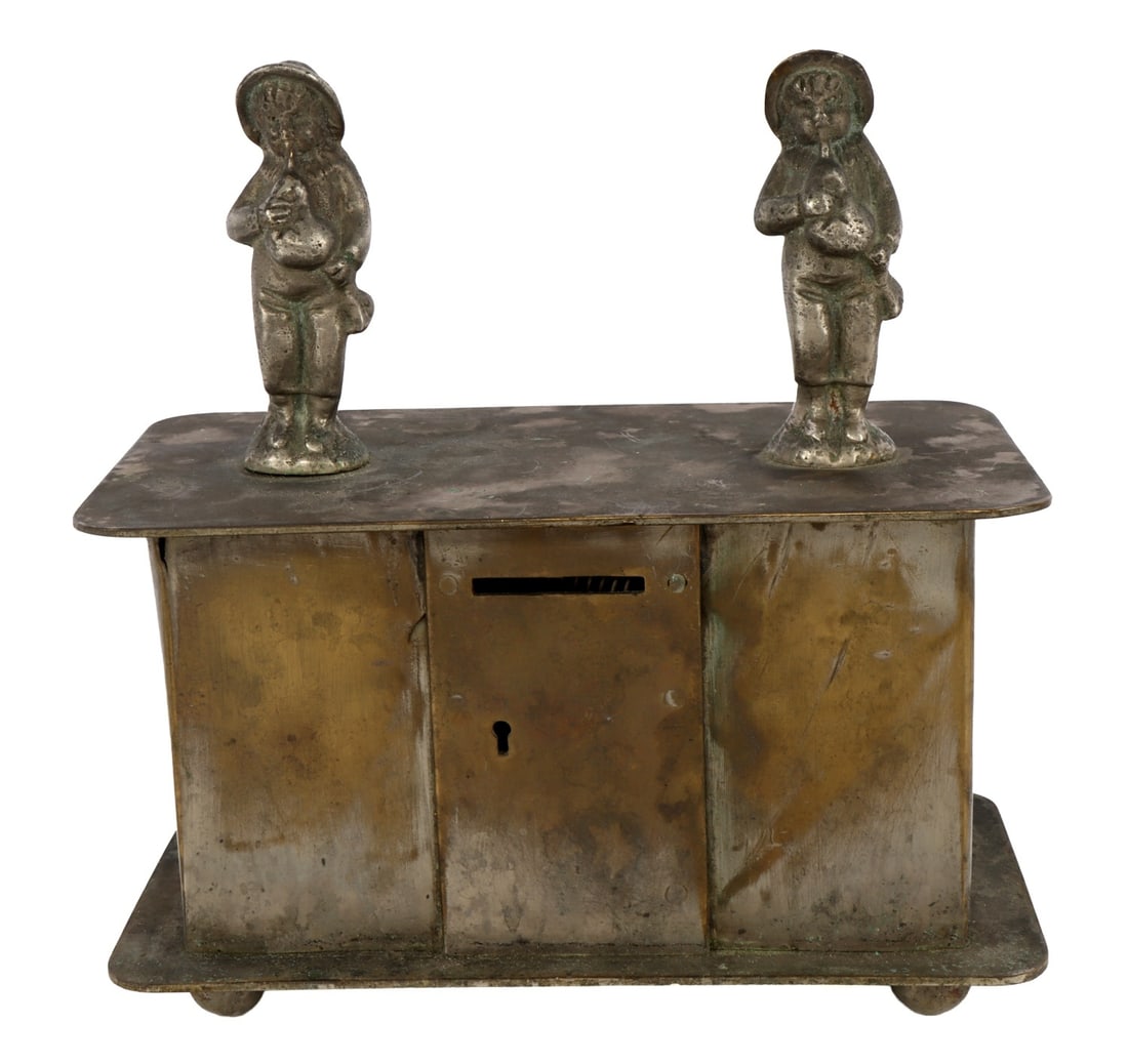 ANTIQUE BRASS COIN BANK WITH MUSICIAN FIGURALS: A brass coin bank with two musician figurals. They appear to be playing a bagpipe-like instrument.
