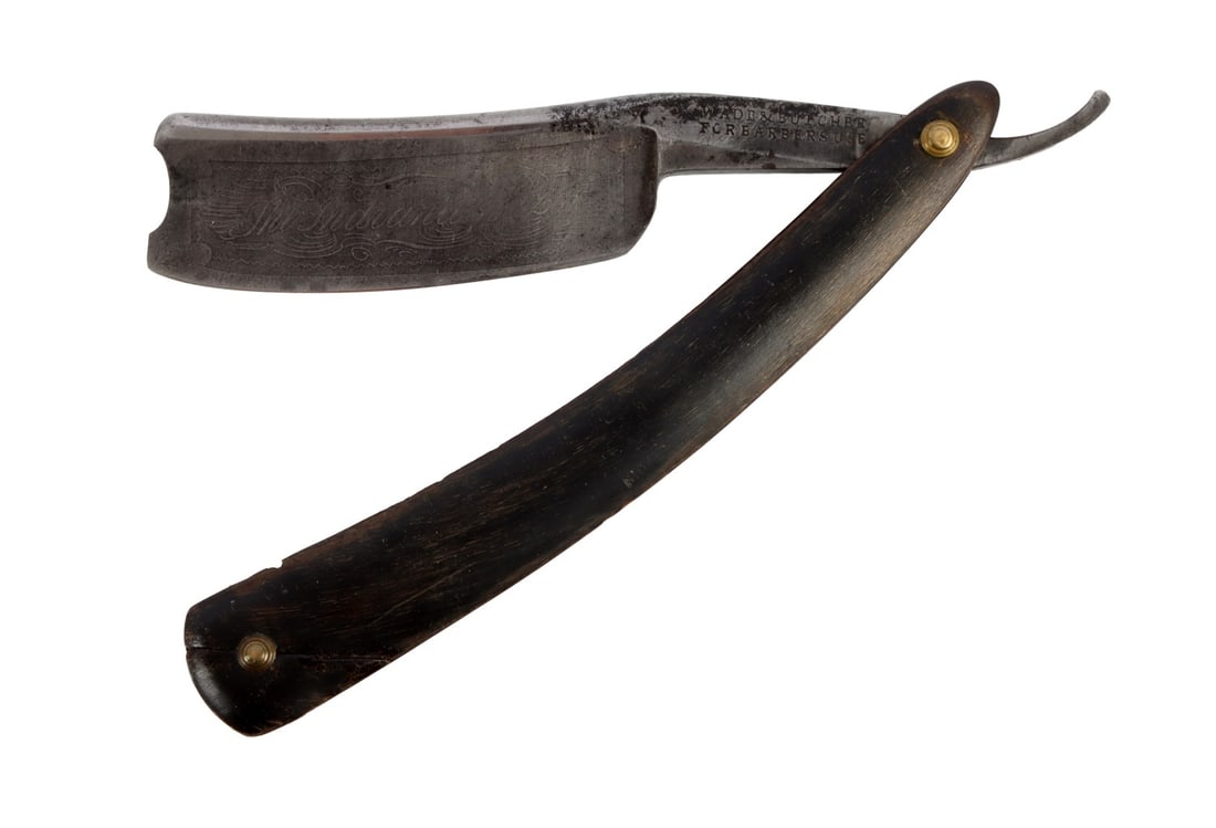 ANTIQUE STRAIGHT RAZOR THE INDIANA RAZOR: An antique straight razor with the slogan 'the Indiana Razor' embossed on to the blade. Approximately 6 inches when folded.