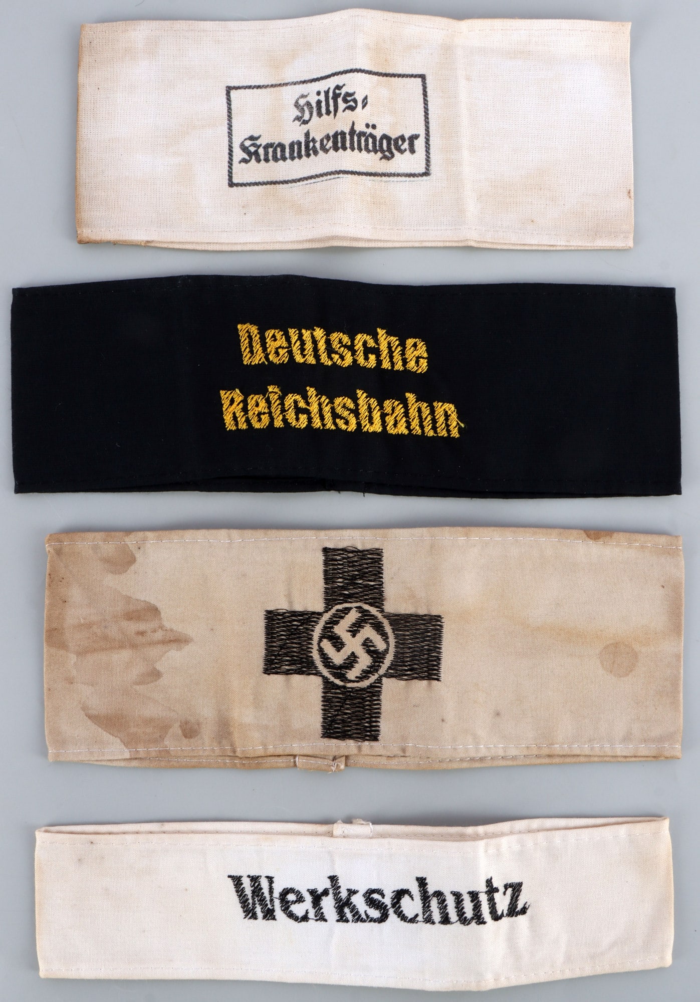 WWII GERMAN THIRD REICH ARMBANDS MIXED LOT OF 4: Four armbands of the German Third Reich. 1) Stretcher bearer. 2) Deutsche Reichsbahn. 3) Work crew. 4) Red Cross. All but work crew fluoresce. Unauthenticated, sold as is.