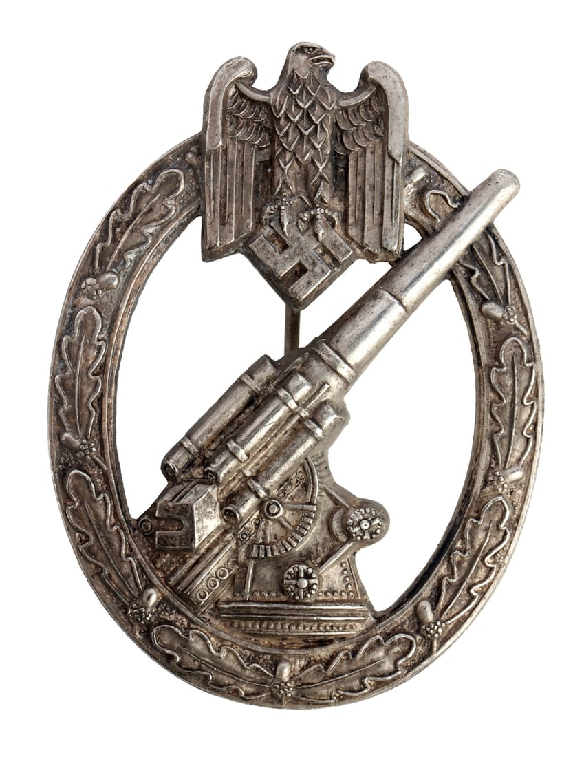 WWII GERMAN ARMY ARTILLERY BADGE: Army Artillery Badge. Silvered kriegsmetall by Hermann Aurich, Dresden. Ball-hinge type. It measures 2 3/8 inches. This lot has a reserve.