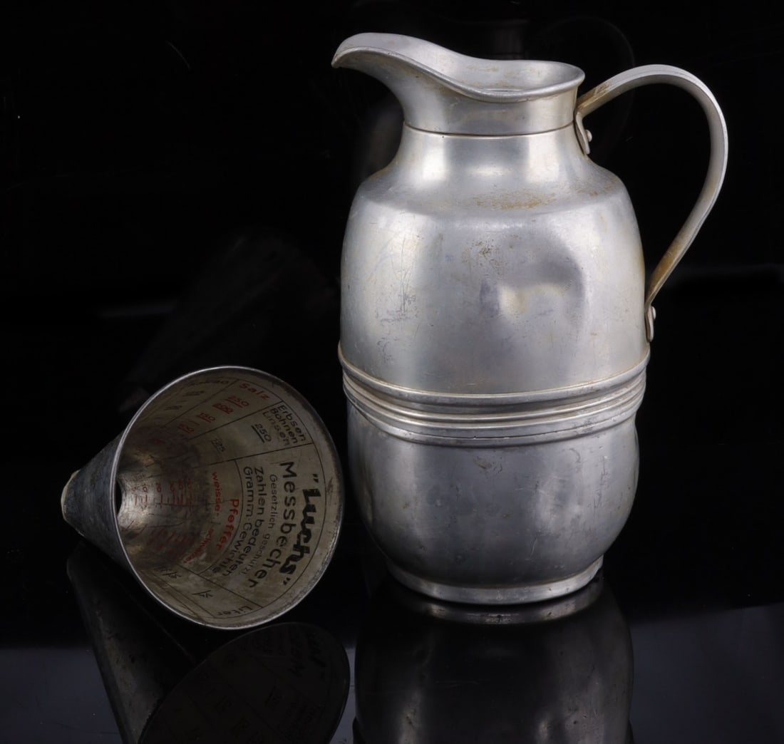 20TH CENTURY GERMAN KITCHEN APPLIANCES LOT OF 2: 1) A Luch's measuring cup. Missing base/sifter. 2) A neusilber jug. Very good, original condition.