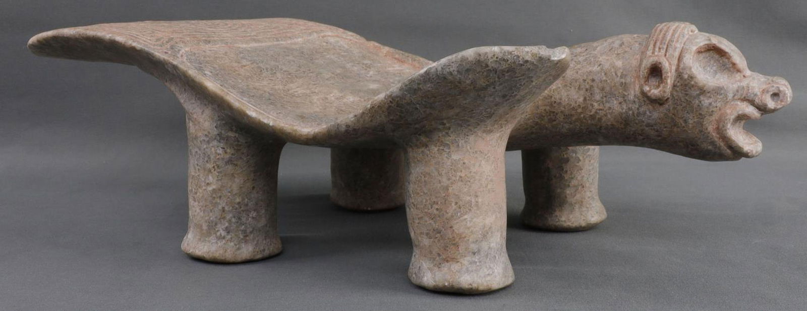 TAINO RITUAL DUHO SEAT: Chip on right shoulder. Typical swirl pattern. Slit below instead of phallus. 15 X 7.25 inches. This lot has a reserve.