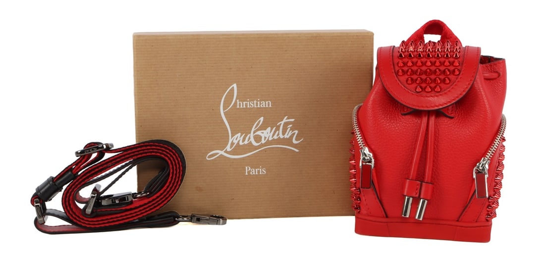 CHRISTIAN LOUBOUTIN EXPLORAFUNK BACK PACK RED: A Christian Louboutin Explorafunk cross body mini backpack for men. With Louboutin signature spikes and leather printed with a red design. Red and black accenting. Comes with backstraps, but