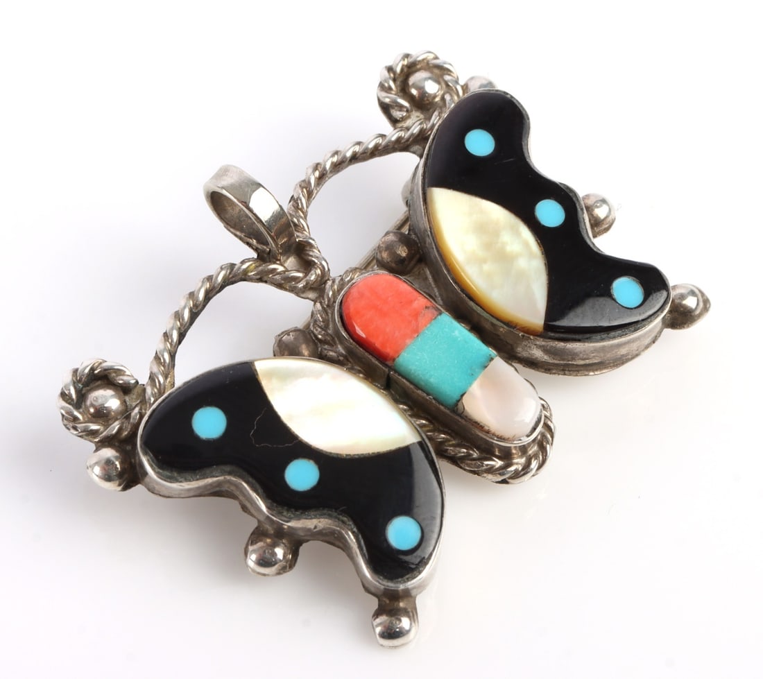 J COONSIS ZUNI BUTTERFLY STERLING PENDANT BROOCH: Zuni butterfly pendant signed by Juan Coonsis. Sterling silver with stone inlay. Size: 1.39 X 1 X 0.2 inches. Stones: Onyx, Turquoise, mother of pearl and coral. Pin back bail opening is 3.98 mm. Acid