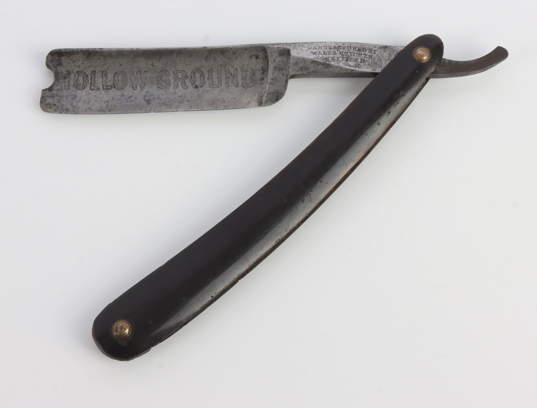 ANTIQUE STRAIGHT RAZOR WADE & BUTCHER: An antique straight razor from Wade & Butcher of Sheffield. Reads "Hollow Ground" on the blade. Celluloid handle.