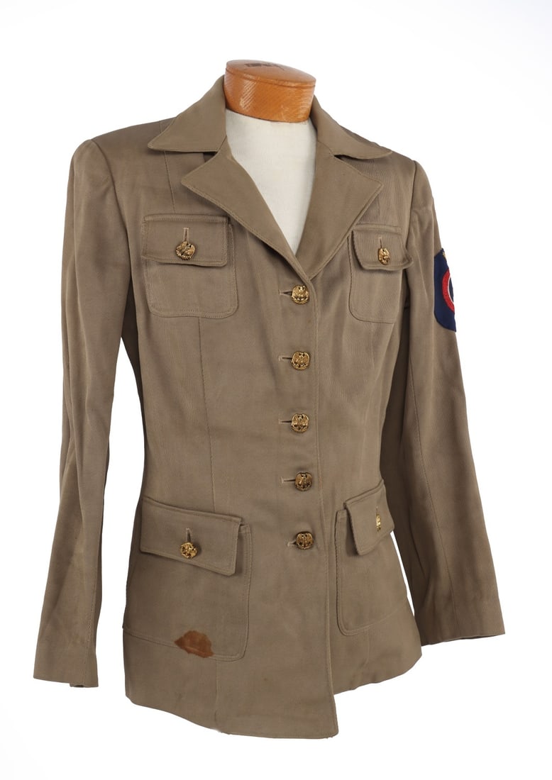 WWII CIVIL DEFENSE DOCTOR WOMEN'S SERVICE JACKET: Civil Defense women's medical service jacket of beige gabardine. Left sleeve has hand embroidered "USA CD" yellow cross insignia patch. Front closure has 5 distinctive buttons, eagles with oak leaves.