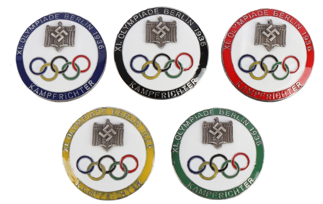 WWII GERMAN THIRD REICH 1936 OLYMPICS BADGES LOT 5: A collection of five badges for the 1936 Berlin Olympics, modeled after the Olympic rings and bearing the Reichsadler. Colors reflect Olympic rings.