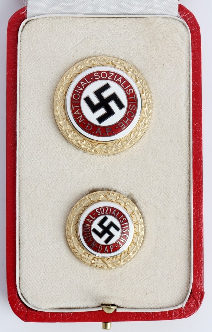 WWII GERMAN THIRD REICH NSDAP PARTY BADGE CASED: A cased version of the NSDAP party badge, in two instances in separate sizes. Party number 5885. Deschler & Sohn. Red case with golden Reichsadler.