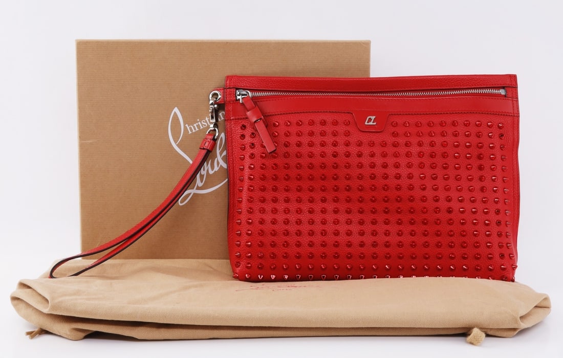 CHRISTIAN LOUBOUTIN SPIKED TONE ON TONE CITY POUCH: A red studded tone-on-tone luxury city pouch from Christian Louboutin. Full grain leather. Six card slots and ample additional interior space. 12.75 X 2 X 9.5 inches. Guaranteed to be authentic. With