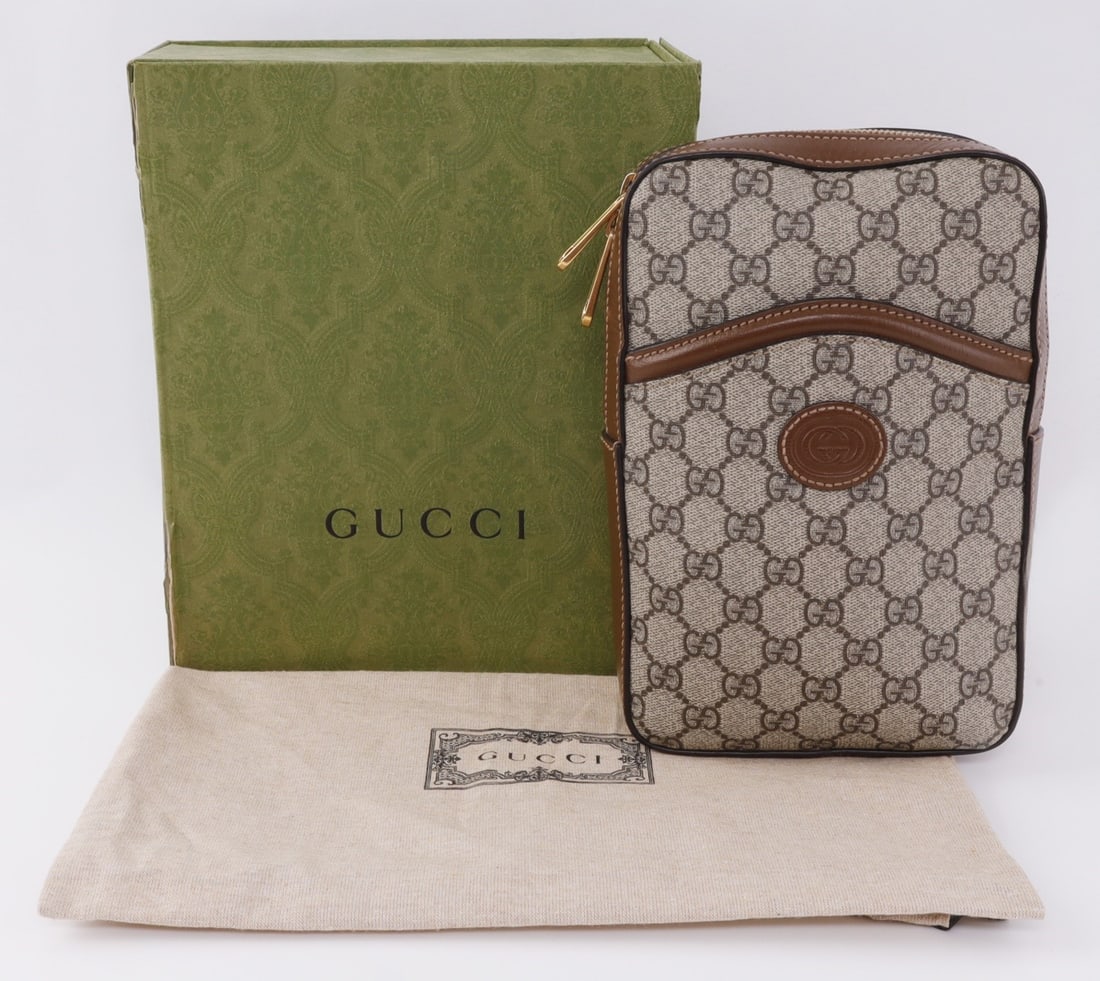 GUCCI INTERLOCKING G PATCH SLING BAG: A luxury Gucci interlocking G patch sling bag with GG canvas. Leather and gold tone accents. With original dust bag and box. 6 X 2.4 X 9 inches. Guaranteed authentic. This lot has a reserve.