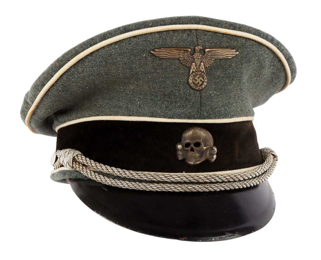 WWII GERMAN THIRD REICH WAFFEN SS VISOR CAP: Grey wool cap with white piping and black velvet band. Name tag "H. Dorn." Silvered Reichsadler and Totenkopf. Hard leather visor. Silk lining and leather sweat band. Size 56 1/2