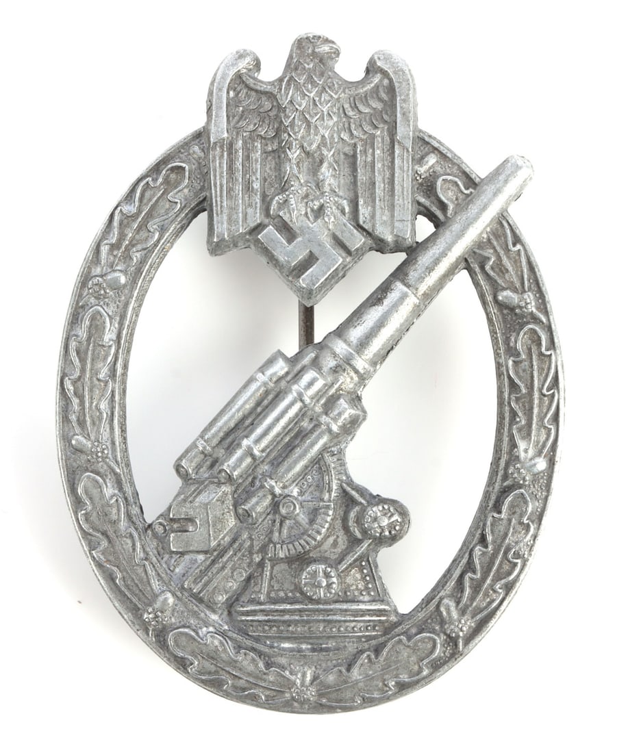 WWII GERMAN ARMY HEER ARTILLERY BADGE: Zinc construction with ball hinge type pin. Hermann Aurich make on reverse. It measures 2 1/4 inches. This lot has a reserve.